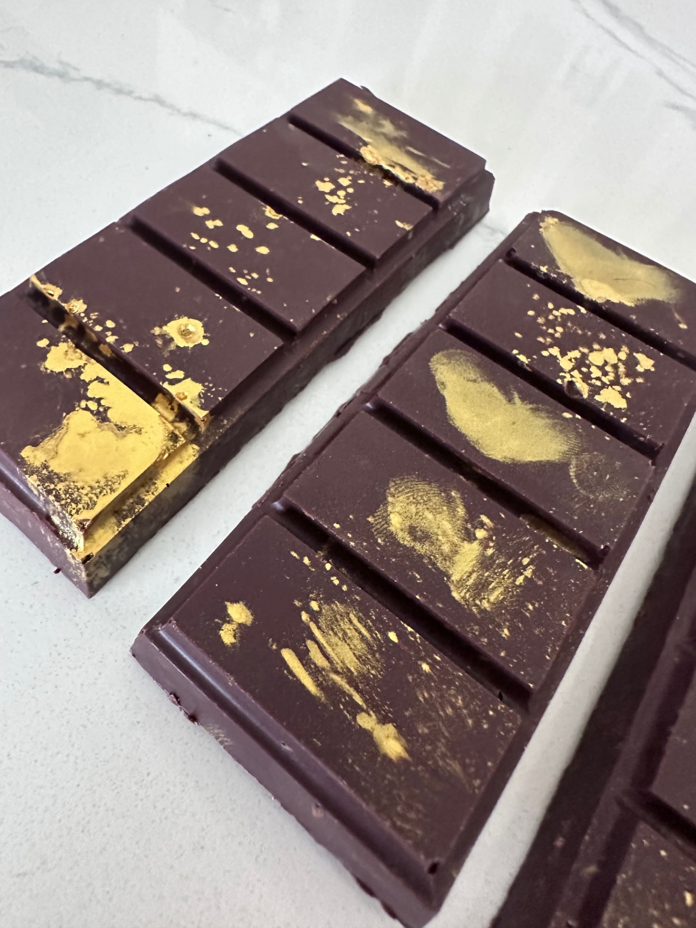 Two gold dusted Dubai chocolate bars side by side